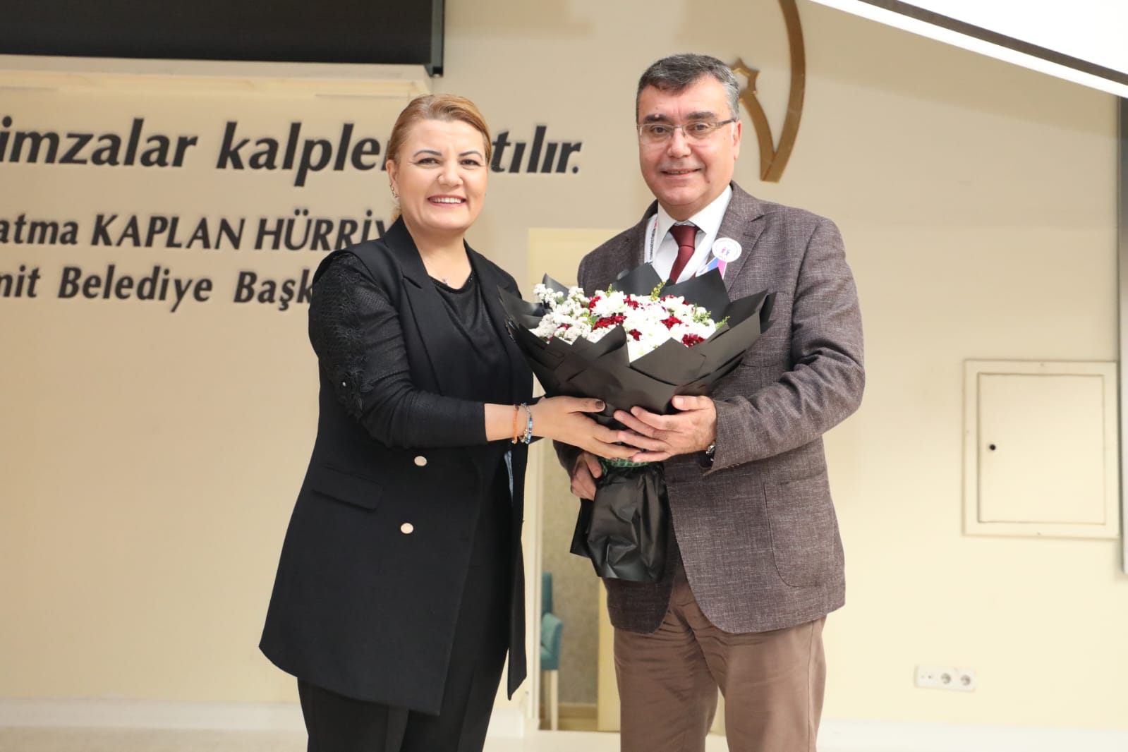 Başkan Hürriyet, Zafer Utkan'a çiçek takdim ederken