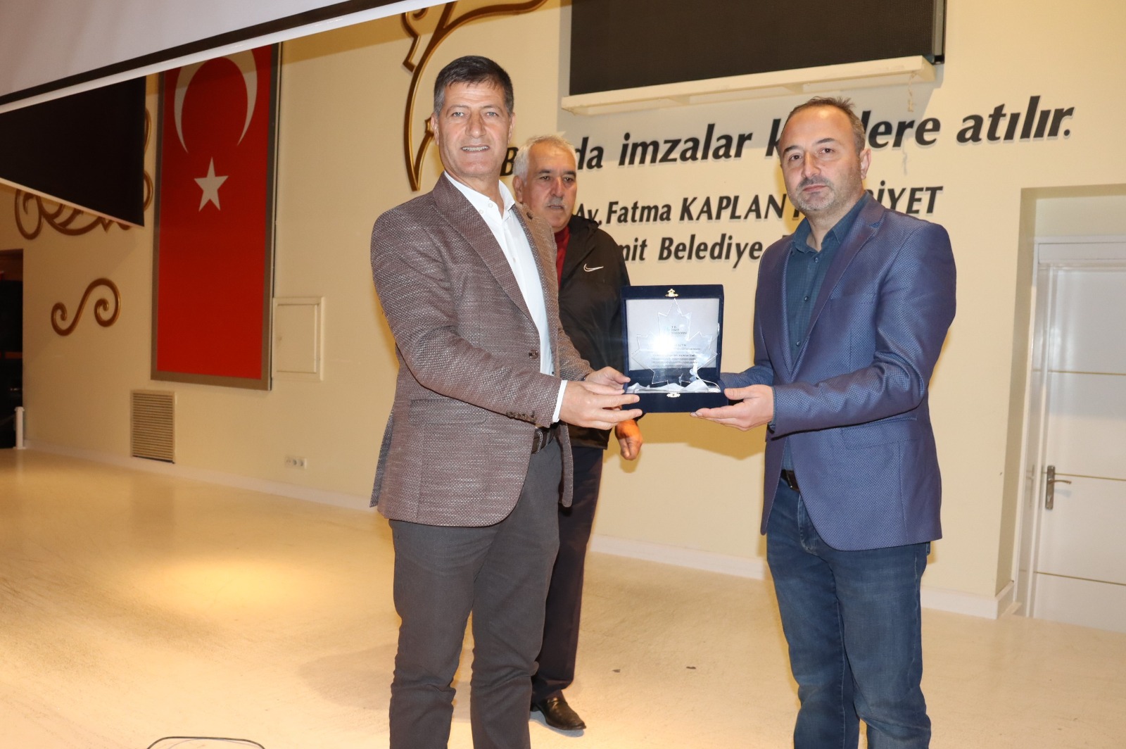 Emirşah Torun Ali Fuat Altın'a plaket takdim ederken