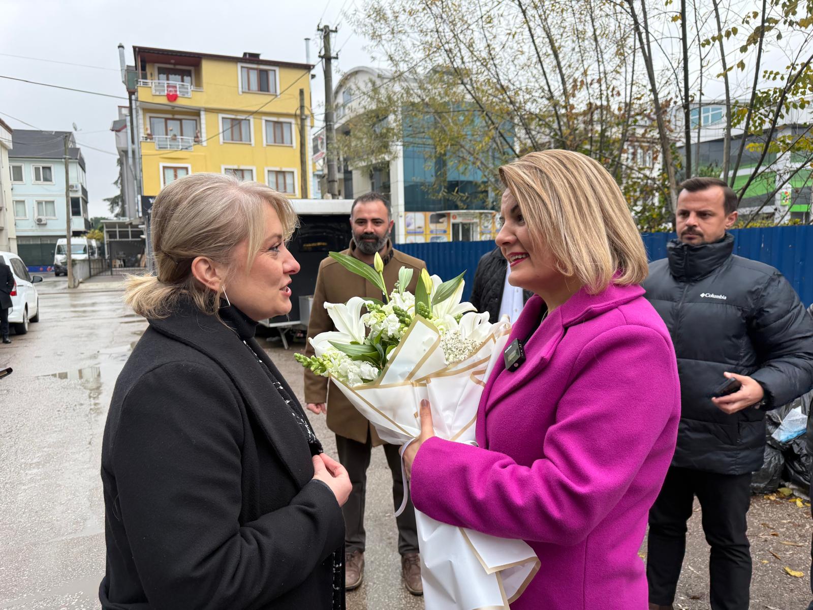 Yenişehir Mahallesi esnaflarından Remax Kaptan Müdürü Tuğba Emir, Başkan Hürriyet’e çiçek takdim ederken